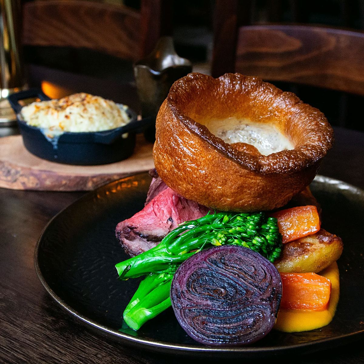 Sunday lunch of roast beef with a Yorkshire pudding, greens and roast roots